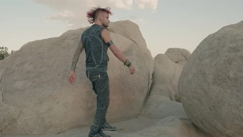 Person Walks Through Desert Rocky Landscape