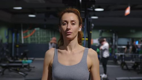 Woman with a Beautiful Physique Plays Fitness in the Gym