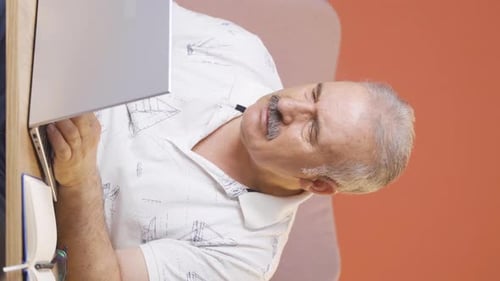 Vertical video of The old man who got angry at what he saw on the laptop.