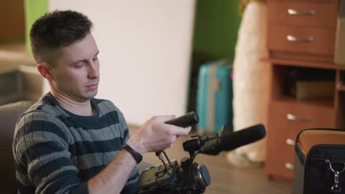 Man Removing Camera from Case in Living Room