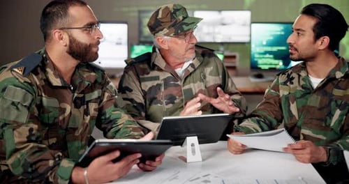 Men in Camouflage Work Together Around Table