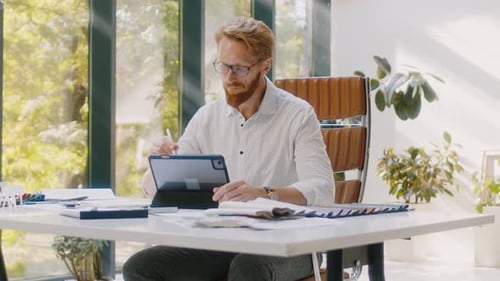 Designer Works on Tablet in Bright Home Office