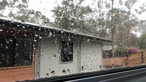 Sharp focus of rain drops on window view looking out at other townhouse
