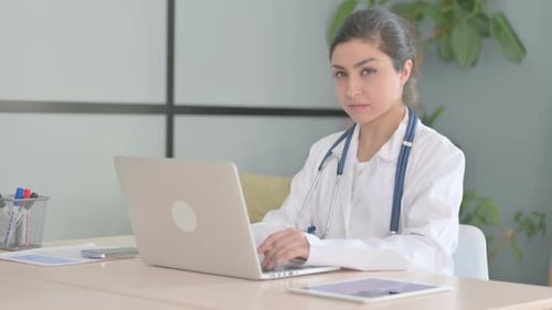 Young Doctor Typing at Desk Says Shush