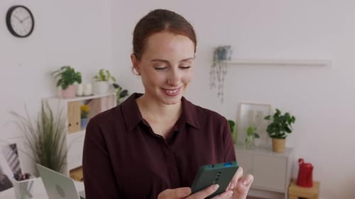 Young Happy Professional Businesswoman Using Mobile Phone at Home Office