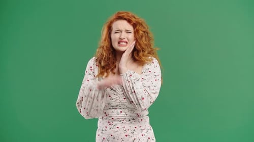 Bright Redhaired Woman with Tooth Pain Green Studio Toothache Dental Problem