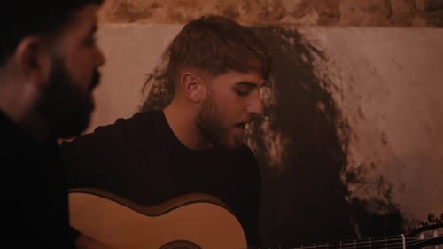 Three Young Adults Singing and Playing Guitar