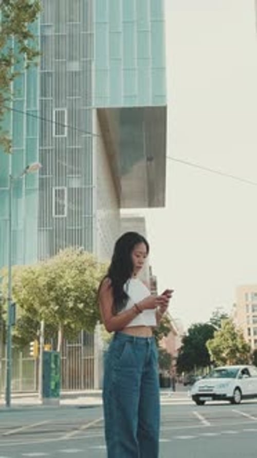 Woman Uses Phone on City Street