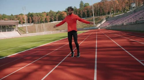 Kaukasischer junger Athlet in Sportkleidung beim Aufwärmübungen zur Vorbereitung auf das Laufen