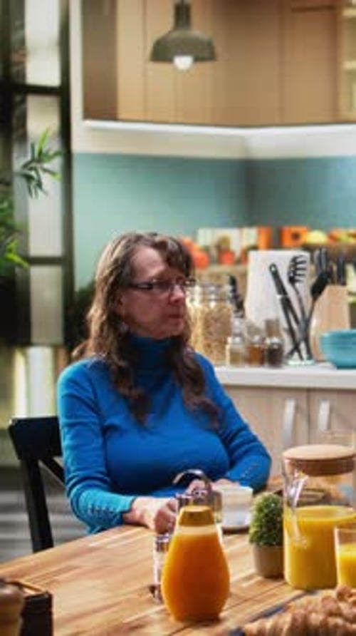 Woman Drinking Coffee at Kitchen Table