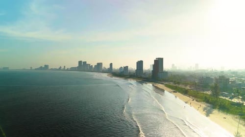 Stunning Aerial View Capturing a Modern Coastal City with High Rise Buildings Sandy Beach Rolling