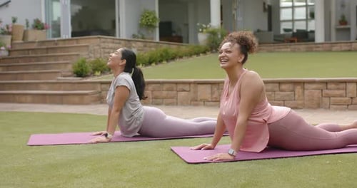 Diversas amigas siguiendo el ejemplo, sosteniendo las curvas hacia atrás a juego sobre tapetes morados en el césped, sonriendo