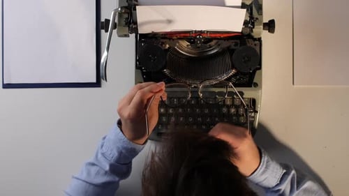 Frustrated Man with Typewriter at Desk Overhead Shot
