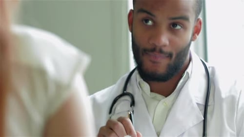 Medical Professional Taking Notes with Patient in Office