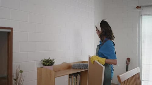 Young Woman Dusting in a Bright Home Interior