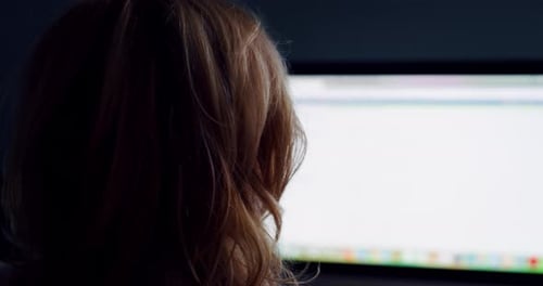 Cinematic slow motion back view shot of middle aged business woman is working with a computer in a