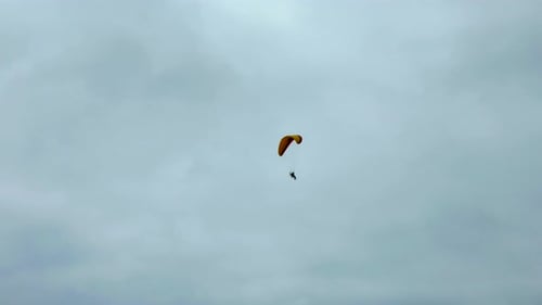 Fallschirmspringer beim Abstieg auf bewölktem Himmel