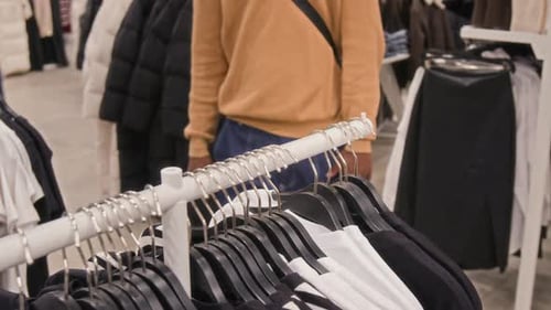 Anonymous Man Choosing Clothes in Store