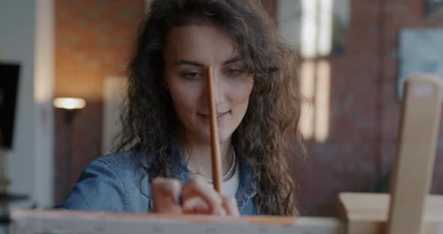 Young Woman Painting with a Brush at Home