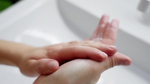 Woman Applying Cream To Hands Indoors