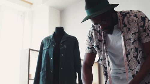 Stylish man designing clothes in his studio