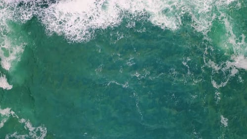 Rough Blue Ocean Splashing Foaming on Stone Cliff Aerial View