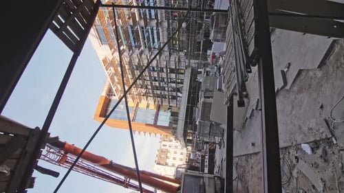 Grúa y materiales cerca del centro de oficinas en el sitio de construcción