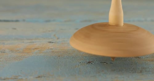 Wooden Spinning Top Spinning on Blue Wood