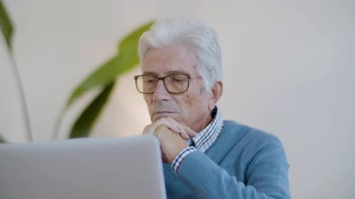 Senior Man Uses Laptop Computer Indoors