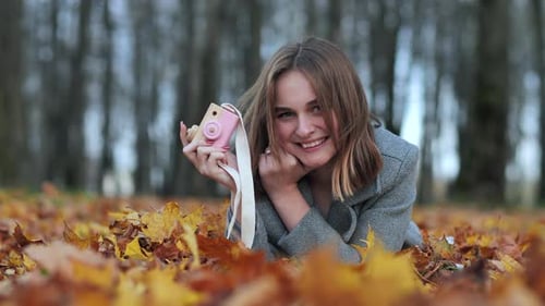 Portrait of Smiling Little Girl Takes Photo with Digital Camera Toy in the Garden Outdoor