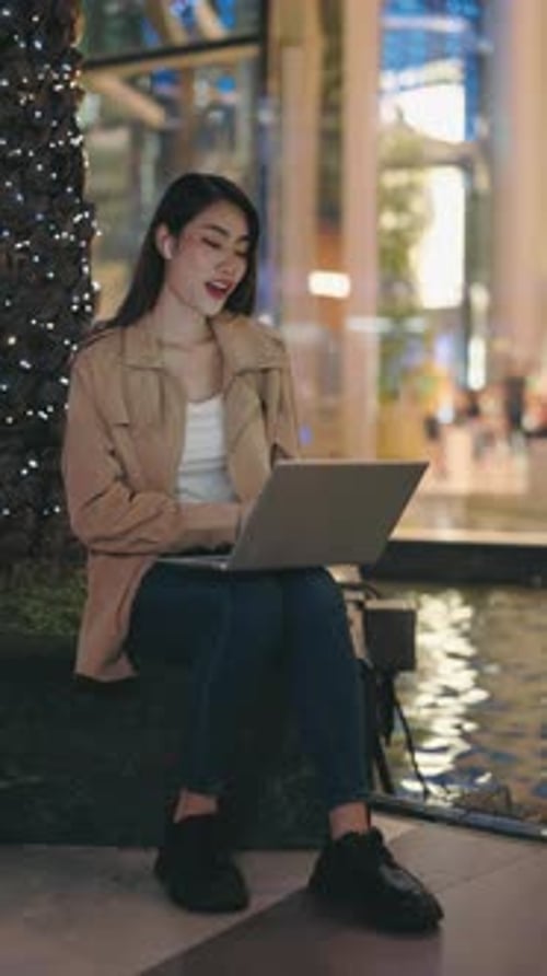Woman Video Calling on Laptop in City at Night