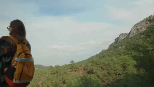 Solitary Woman Travels Through High Mountains in the Forest and Takes Photos on her Smartphone.