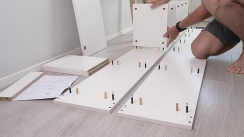 Man Assembling Flat Pack Furniture at Home