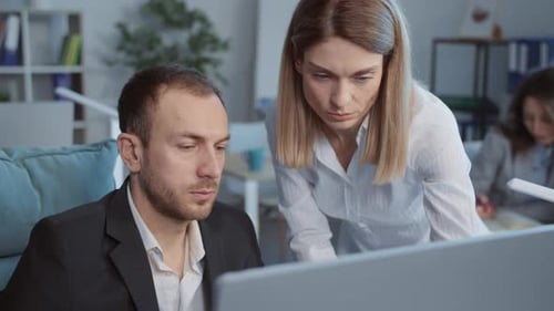 Coworkers in Office Discussing Project on Computer