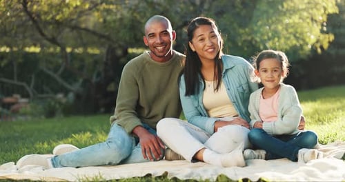 Smiling Family Relaxing Together in Green Park