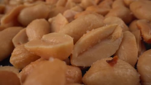 Toasted salted peanuts macro moving, food product used in many tasty recipes like chocolates, sauces