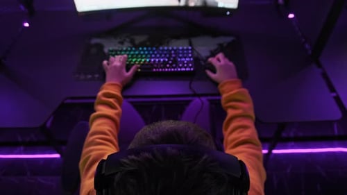 Young Gamer Sits in Gaming Chair and Plays Video Game at ESport Club