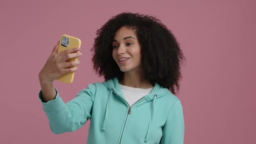 Woman Takes Selfie Using Yellow Smartphone