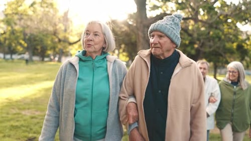 Senior couple, walking and talking in park together for morning exercise