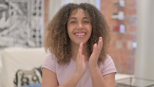 Porträt einer aufgeregten Afroamerikanerin, die für das Team klatscht