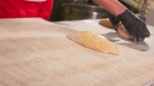 A woman lays out the dough for making bread