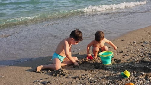 cute siblings, brothers are playing on sea beach.