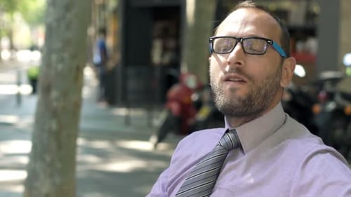 Portrait of Young Businessman Eating Sandwich on Bench in City 30s