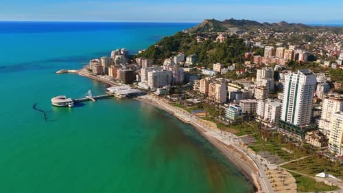 Aerial drone view of the iconic circular Rotonda building extending over the turquoise waters of the