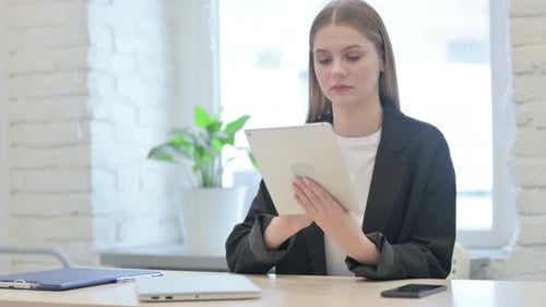 Young Woman Using Tablet Device in Modern Office