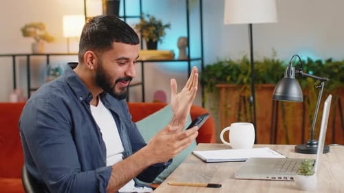 Happy Amazed Indian Man Guy Working on Smartphone Celebrate Victory Winning Lottery at Home Office
