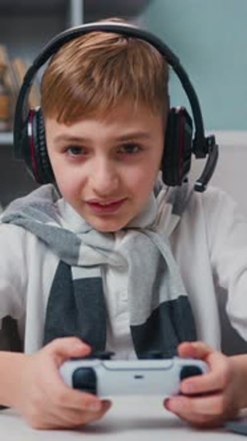 Boy Plays Video Games with Headset Indoors
