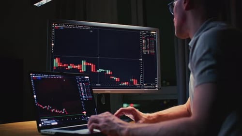 Man Stock Trader in Home Office Male Analyzes Terminal Trades Stocks on Crypto Market Quotes From
