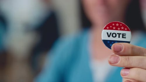 Hands of Anonymous Woman Holding US Election Campaign Badge