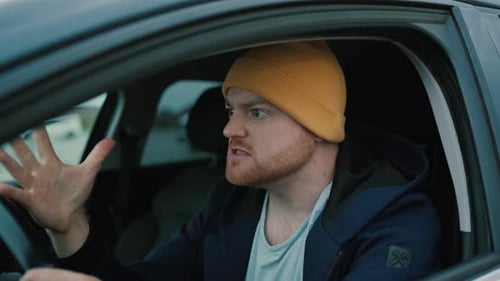 Frustrated Man Driver Showing Fingers During Road Trip in Car